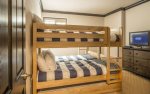 5th bedroom with two sets of twin bunks sleeps 4, flat-screen television, and en-suite bathroom.